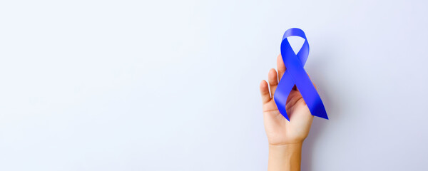 hand hold navy blue ribbon for cancer Awareness, Colorectal Cancer, a Colon cancer.