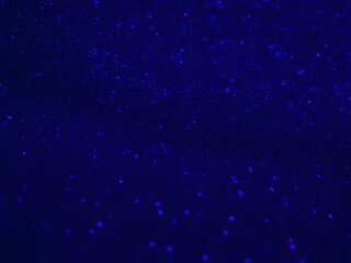 A beautiful abstract blue glitter defocused darker background