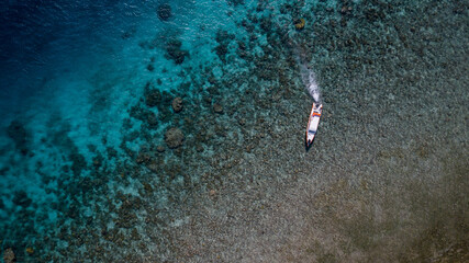 Topview eascape featuring a speeding boat leaving a white trail on the serene blue ocean