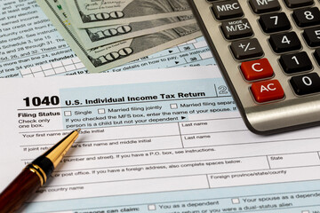 1040 federal individual income tax return forms, cash money and calculator. Federal tax return, income tax and tax refund concept.
