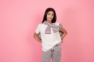 Young smiling teenage girl on pink background in studio.