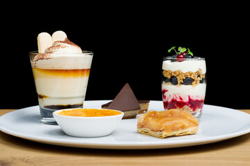 A selection of desserts for two on a wooden table with a dark background