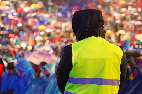 guard in the stadium packed with people with the phosphorescent vest to control people