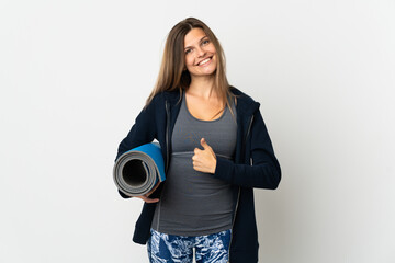 Slovak girl going to yoga classes isolated on white background giving a thumbs up gesture