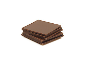 Stack of thin square pieces of chocolate isolated on white background.