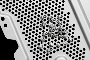 Small screws on perforated metal cover. Electronic components disassembly