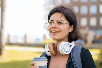 Young pretty Bulgarian woman at outdoors holding a take away coffee