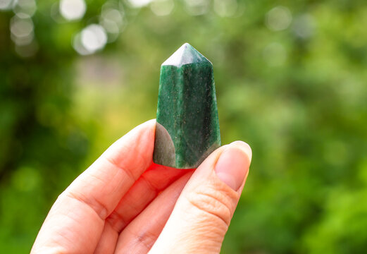Natural mineral jade in hand on natural background
