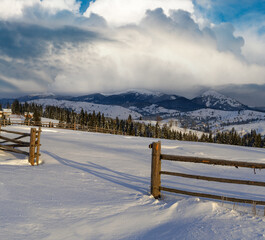 Morning countryside hills, groves and farmlands in winter remote alpine mountain village