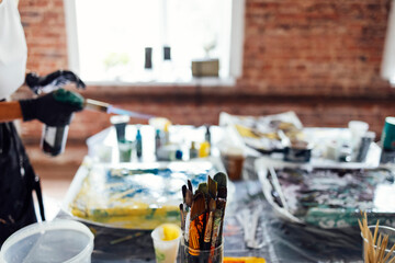 Woman uses a gas burner to draw in Fluid Art. Process of creating a painting with liquid acrylic paints.