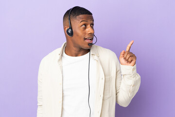 Telemarketer latin man working with a headset isolated on purple background intending to realizes the solution while lifting a finger up
