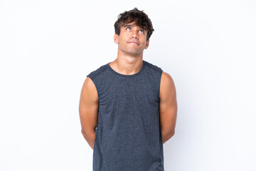 Young sport caucasian man isolated on white background and looking up