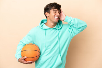 Handsome young basketball player man isolated on ocher background smiling a lot