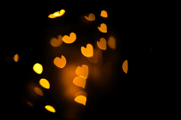 blurred bokeh withe hearts in golden, yellow colors on black background 6