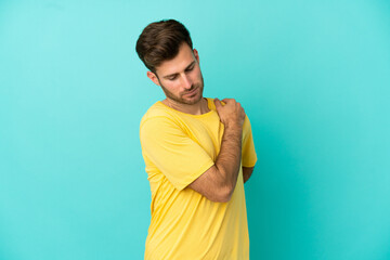 Young caucasian handsome man isolated on blue background suffering from pain in shoulder for having...