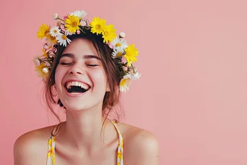 Tuinposter Cheerful girl in wreath of bright flowers on pink background. Portrait of a beautiful woman in spring or summer. Concept of beauty and tenderness. Girl with natural makeup. Banner with copy space © dreamdes