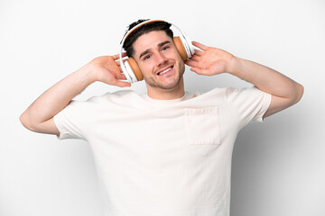 Young caucasian man isolated on white background listening music