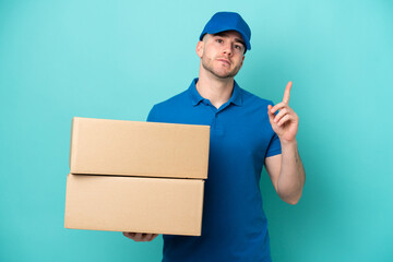 Delivery caucasian man isolated on blue background thinking an idea pointing the finger up