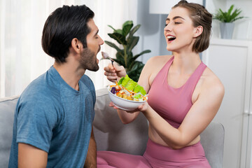 Healthy sporty and vegetarian couple in sportswear with a bowl of fruit and vegetable. Healthy cuisine nutrition and vegan lifestyle for fitness body physique at gaiety home concept.