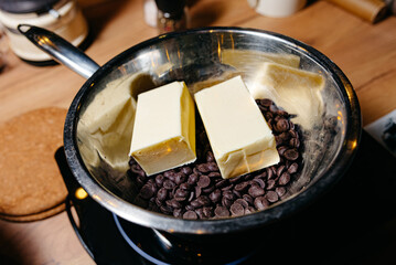 Melting Chocolate and Butter for Baking in Pan. A double boiler pan with dark chocolate chips and blocks of butter, a classic technique for melting ingredients smoothly for baking.