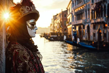  A serene morning at the Venetian Carnival, a lone figure in a traditional mask and costume, standing by the edge of a canal with historical Venetian buildings and gondolas in the background © bluebeat76
