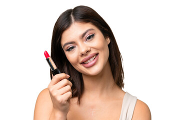 Young Russian woman with rainproof coat and umbrella over isolated chroma key background holding red lipstick