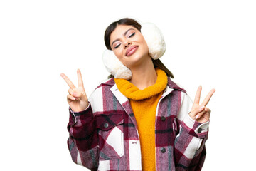 Young Russian woman wearing winter muffs over isolated chroma key background showing victory sign...