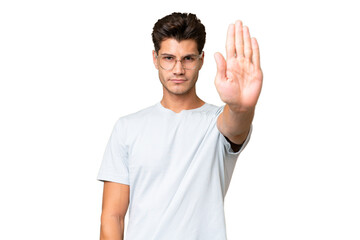 Young caucasian handsome man over isolated background making stop gesture