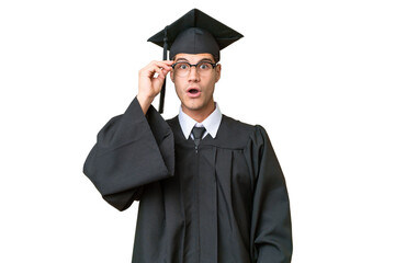 Young university graduate caucasian man over isolated background with glasses and surprised