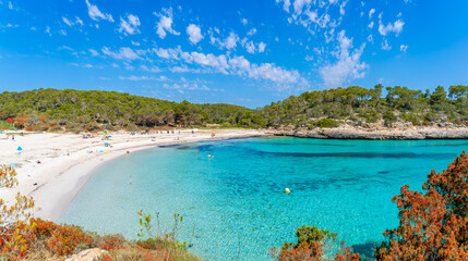 Discover Cala Mondrago's idyllic shores, with soft white sands, clear turquoise waters, nestled in Mallorca's lush Mondrago National Park.