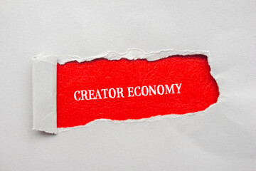 Creator economy lettering on ripped gray paper with red background. Conceptual business photo. Top...
