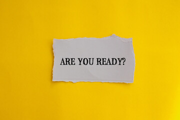Are you ready? question lettering on ripped paper piece with yellow background. Conceptual photo. Top view, copy space for text.