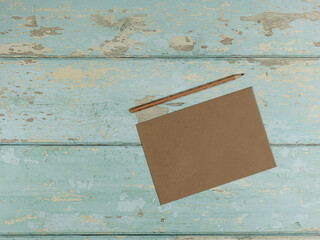 Paper card, pencil on vintage wooden background. Top view. - 704561441