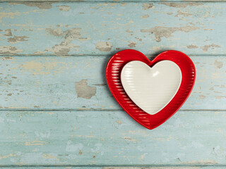 Heart shaped plates on vintage wooden background. Top view. - 704561447