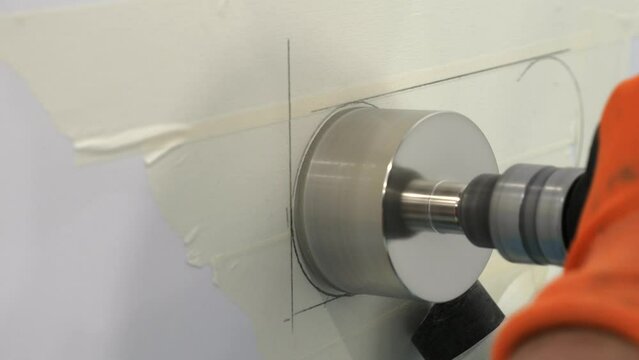 Drilling and cutting holes in porcelain stoneware on wall. Closeup