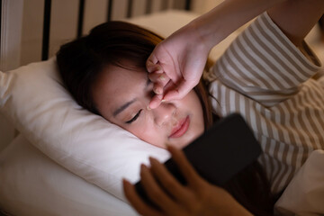 Insomnia asian woman using mobile phone on her bed at night