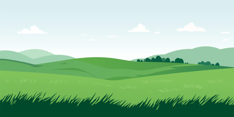Landscape of green meadows and fields. Beautiful summer panoramic landscape with lush grass against a blue sky with clouds.