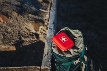First aid kit is on the backpack, first aid on the trip, trekking in the mountains, personal equipment, first aid kit. - obrazy, fototapety, plakaty