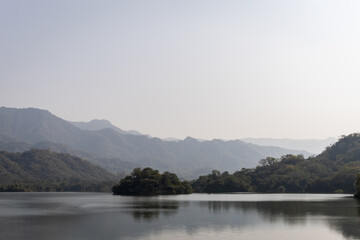 misty mountain landscape with pristine lake at day from flat angle