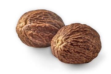 Two brown nutmegs close up isolated on white background