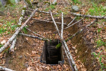 old pirate robbery mine for searching for jewelry and artifacts, excavated from an ancient burial site in the forest of the Western Caucasus on a sunny summer day