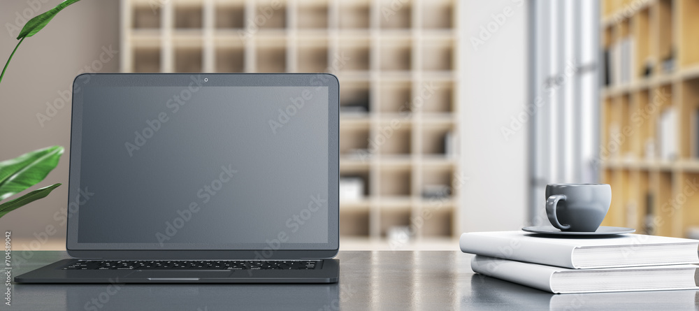 Poster modern wide designer office desktop with empty mock up laptop screen, coffee cup on stacked books an