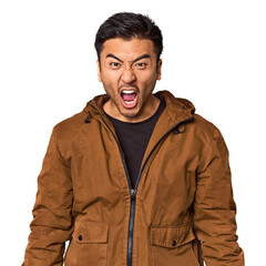 Young Chinese man in studio background shouting very angry, rage concept, frustrated.