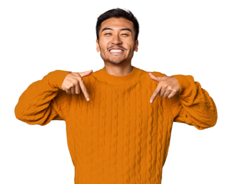Young Chinese man in studio background points down with fingers, positive feeling.