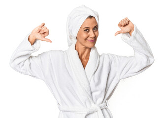 Middle-aged woman with towel post-shower in studio feels proud and self confident, example to follow.