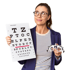 Middle-aged optometrist with vision test chart in studio © Asier