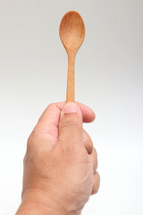 Hand holding a wooden spoon