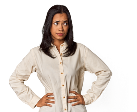 Young Filipina with long black hair in studio confused, feels doubtful and unsure.