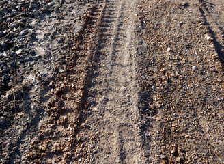 Traces of a work vehicle on a dirt road - 704606694