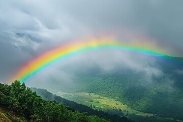 Rainbow arching gracefully over a misty valley